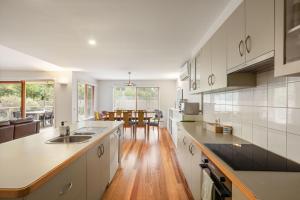 a kitchen with white cabinets and a wooden floor at Beach House Silverleaves in Cowes