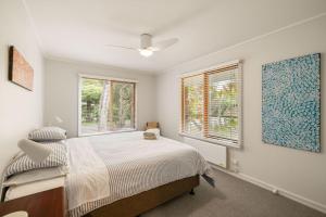 a bedroom with a bed and two windows at Beach House Silverleaves in Cowes