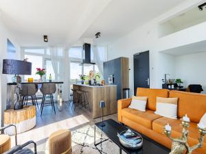 a living room with a couch and a table at Penthouse with beach view in Sint Annaland
