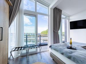 a bedroom with a bed and a large window at Penthouse with beach view in Sint Annaland