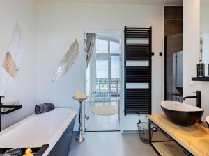 a bathroom with a bath tub and a sink at Penthouse with beach view in Sint Annaland +48 photos