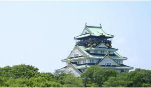 a tall building with trees in front of it at 一休居 in Osaka