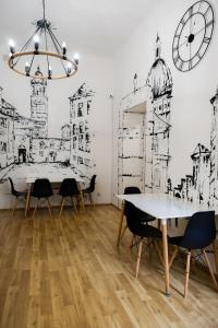 a dining room with a table and chairs and a clock at Fivehostel in Krakow