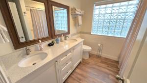 a bathroom with a sink and a mirror and a toilet at The Lindon House in Lindon