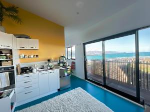 a kitchen with a large window with a view at Epic Ocean Views & Outdoor bath in Wellington