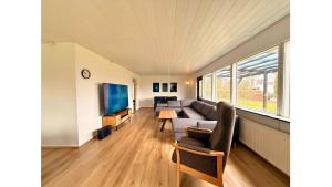 a living room with a couch and a tv at 4 Bedrooms Cozy & Spacious Villa - Lalandia & Puttagrden & Femern in Rødby