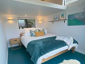a bedroom with a bed and a window at Epic Ocean Views & Outdoor bath in Wellington