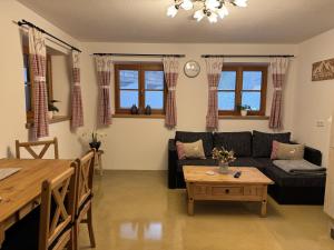 a living room with a couch and a table at Ferienwohnungen Kieferbachtal in Kiefersfelden