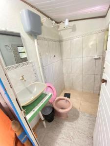 a bathroom with a pink toilet and a sink at Pousada e Hostel Cantinho dos Chalés in São Luiz do Paraitinga +19 photos