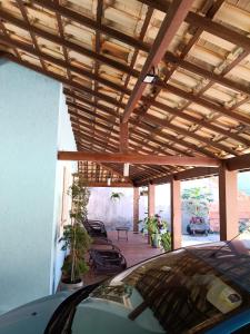 a car parked under a wooden pergola at Recanto da gell in Búzios
