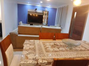 a living room with a table and a couch at Recanto da gell in Búzios