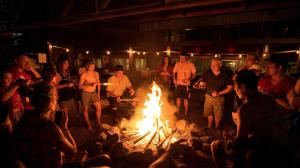 a group of people standing around a fire at Nakai Resort in Ban Nakay Nua
