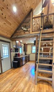 a kitchen with a loft with a staircase in a house at Couples Getaway Cabin with a Loft Bed - Firepit - Creek Access in Dahlonega +21 photos