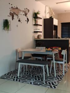a table and chairs in a living room with a table and a desk at PORT DICKSON HomeStay, Family 2 BR Netflix Wifi in Port Dickson
