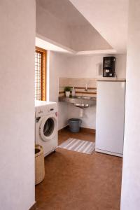 a kitchen with a washing machine and a sink at Casa Horizon in Sultan Bathery