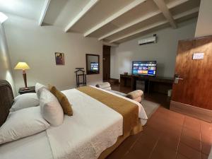 a bedroom with a bed and a flat screen tv at Posada El Remanso de Pueblo Nuevo in San Cristóbal +124 photos