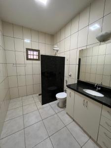 a bathroom with a toilet and a sink at Casa aconchegante com 2 quartos, próximo ao Centro, UFU, Center Shopping e Convention, Hospitais e Aeroporto in Uberlândia +42 photos