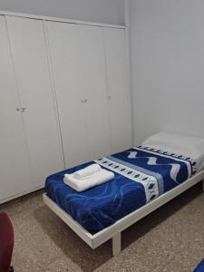 a bedroom with a bed with blue and white sheets at DepartamentoJAP in Venado Tuerto