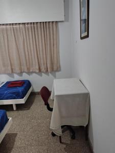 a room with a bed and a table and a bed and a window at DepartamentoJAP in Venado Tuerto +1 photo
