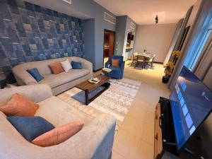 a living room with couches and a flat screen tv at كيان ايقونة الشاطئ ｋａｙａｎ in King Abdullah Economic City