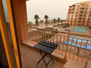 a balcony with a chair and a view of the beach at كيان ايقونة الشاطئ ｋａｙａｎ in King Abdullah Economic City