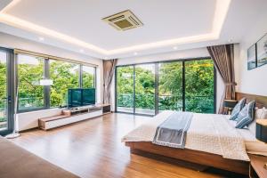 a bedroom with a large bed and large windows at Villa FLC Sầm Sơn Thanh Hoá in Sầm Sơn +41 photos