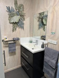 a bathroom with a sink and a mirror at Te Mata Bay Seaviews in Tapu