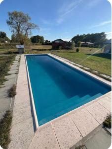 a large blue swimming pool in a yard at Cabañas Campestres Inés in Chillán