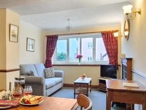 a living room with a couch and a tv at Bracken Cottage-B5817 in Wheddon Cross