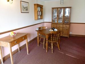 a dining room with a table and a cabinet at Bracken Cottage-B5817 in Wheddon Cross