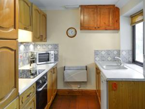 a small kitchen with a sink and a microwave at Bracken Cottage-B5817 in Wheddon Cross