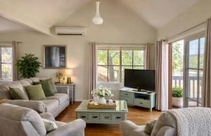 a living room with a couch and a tv at Balingup Highview Chalets in Balingup
