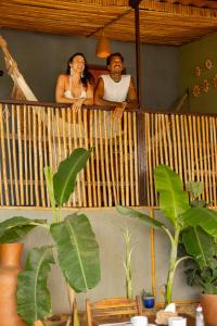 a man and a woman sitting on a balcony at Pousada Unaí - Casa Flor in Fernando de Noronha