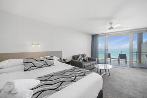 a bedroom with a bed and a view of the ocean at The Dorsal Boutique Hotel in Forster