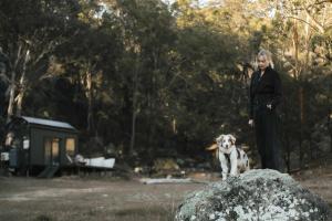 a woman and a dog standing next to a rock at Tiny Maggie in Rylstone +25 photos