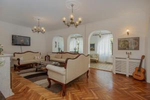 a living room filled with furniture and a guitar at Villa Paradiso in Donji Morinj