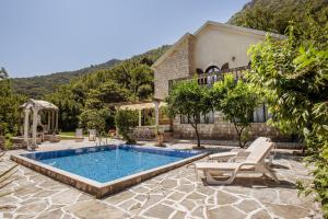 a swimming pool in front of a house at Villa Paradiso in Donji Morinj