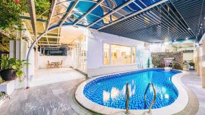a swimming pool in a building with a ceiling at Happy Villa in Sầm Sơn