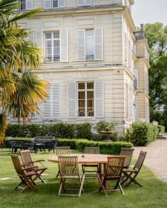 a group of chairs and a table in front of a house at Chateau du boulay morin in Le Boulay-Morin
