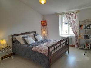 a bedroom with a bed with pillows and a window at Maison en pierres rénovée avec patio à Ferrières-sur-Sichon - FR-1-489-191 in Ferrières-sur-Sichon