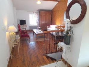 a living room with a table and a mirror at Maison en pierres rénovée avec patio à Ferrières-sur-Sichon - FR-1-489-191 in Ferrières-sur-Sichon +16 photos