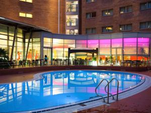 a swimming pool in front of a building at Novotel Venezia Mestre Castellana in Mestre