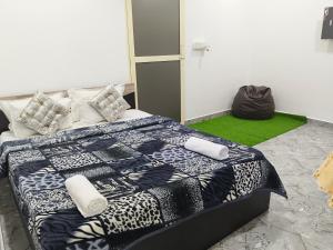 a bedroom with a bed with a black and white quilt at Eva Beach Side Room in Mandrem