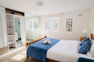 a bedroom with a large bed with a blue blanket at Sydney Harbour Side Waterfront Apartment in Sydney