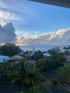 a view of a town with a lighthouse in the distance at Évasion Tropicale à Tartane in Tartane