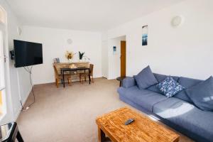 a living room with a blue couch and a table at Sydney Harbour Side Waterfront Apartment in Sydney