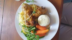 a plate of food with meat and vegetables on a table at white hart hotel murrurundi in Murrurundi +6 photos