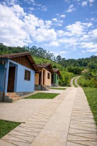 a road in front of some houses on a hill at Chalés do Lago Lumiar in Nova Friburgo