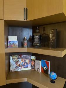 a shelf with a bottle of whiskey and books at Sunshine Place in Elbasan