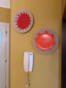 two plates and a phone on a wall at Sunshine Place in Elbasan